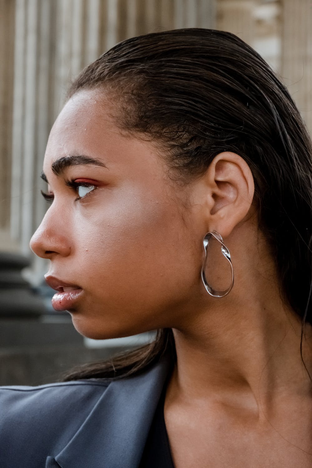 woman with hoop earring jewelry looking to the side 
